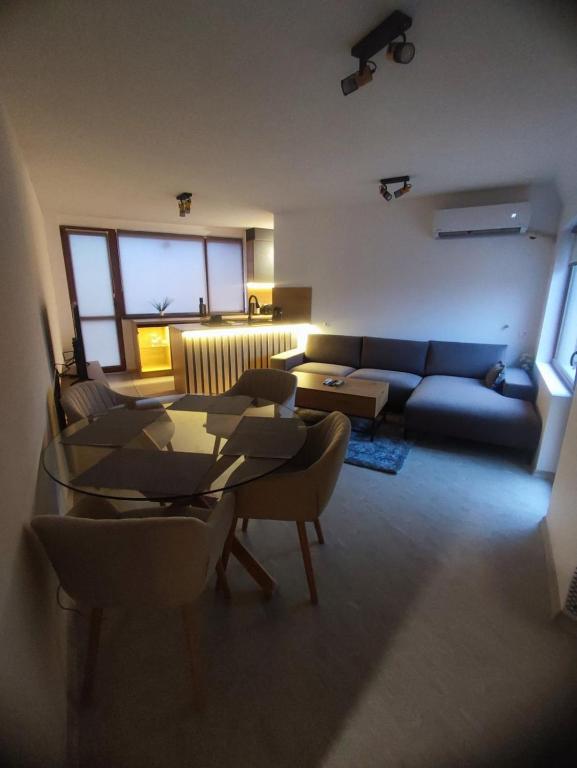 a living room with a couch and a table and chairs at Апартамент Skyline in Yambol