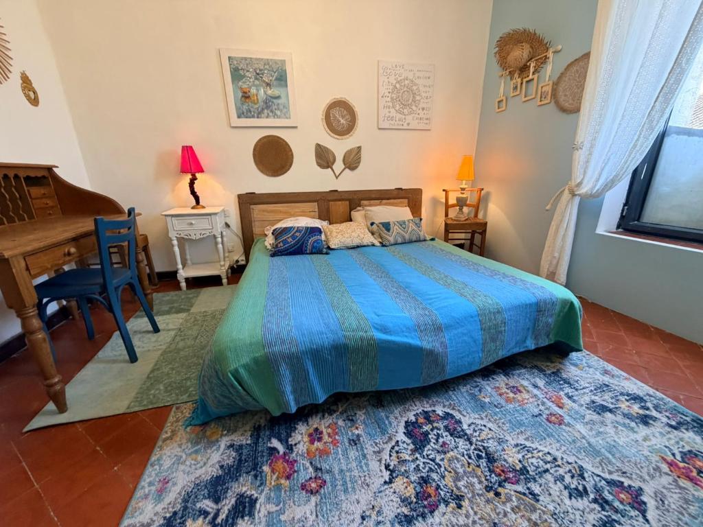 a bedroom with a bed and a desk and a piano at La Vigneronne in Maureilhan-et-Raméjan