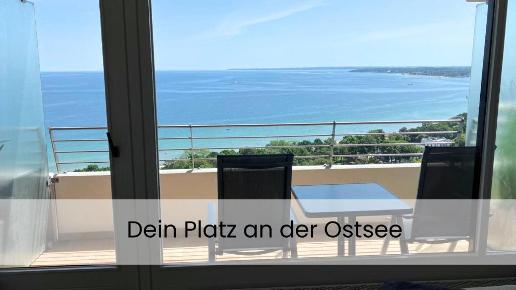a view of the ocean from a balcony with a table and chairs at Apartment Ostseeblick 131 in Timmendorfer Strand