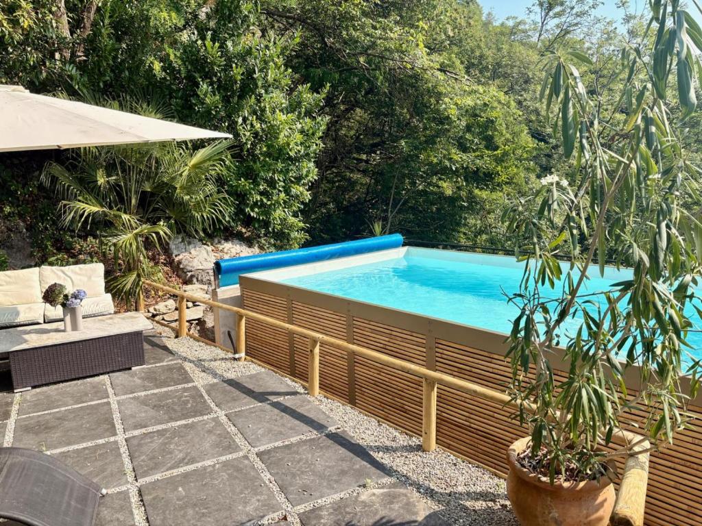 a swimming pool in a backyard with a table and an umbrella at Raggio di Sole Villa in Oggebbio