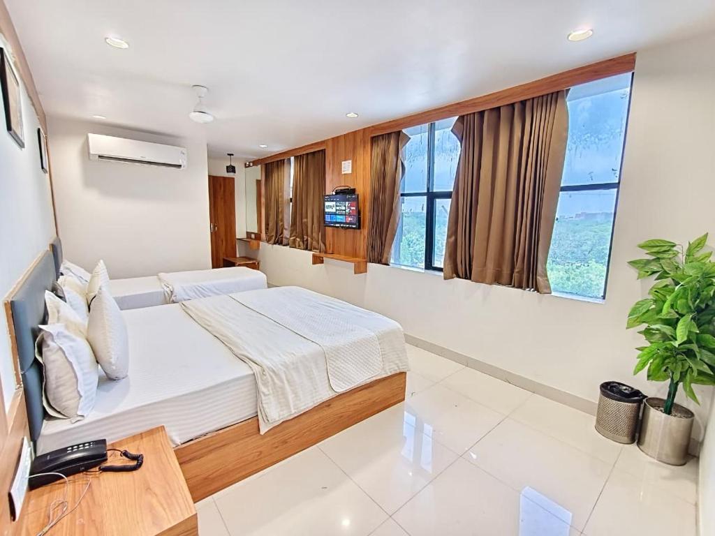 a bedroom with a bed and a tv in it at Hotel Royal Relax in Gandhinagar
