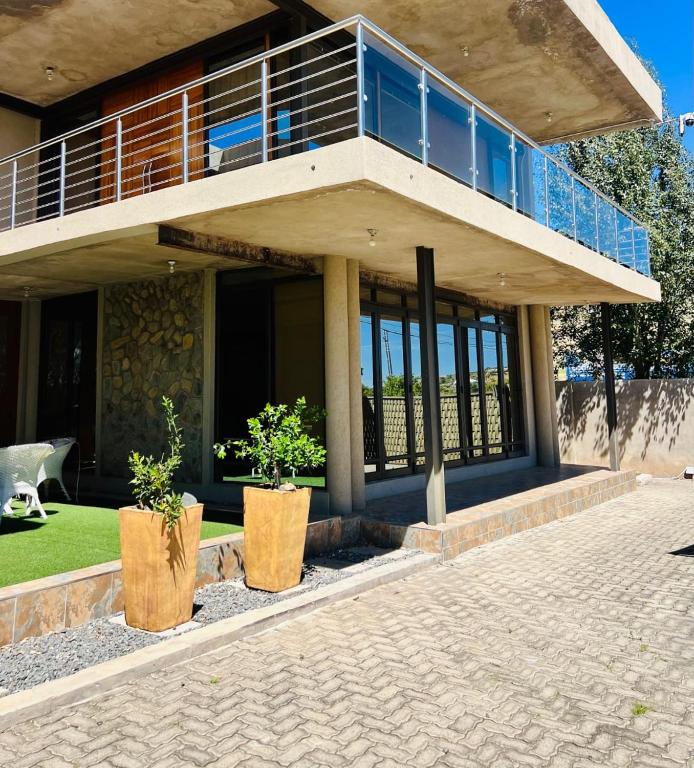 a house with two potted plants in front of it at Mosia Guest House in Maseru