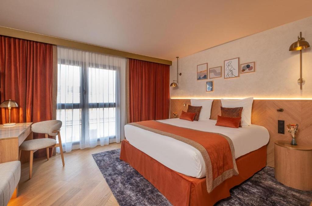 a hotel room with a large bed and a desk at Hôtel Burdigala by Inwood Hotels in Bordeaux