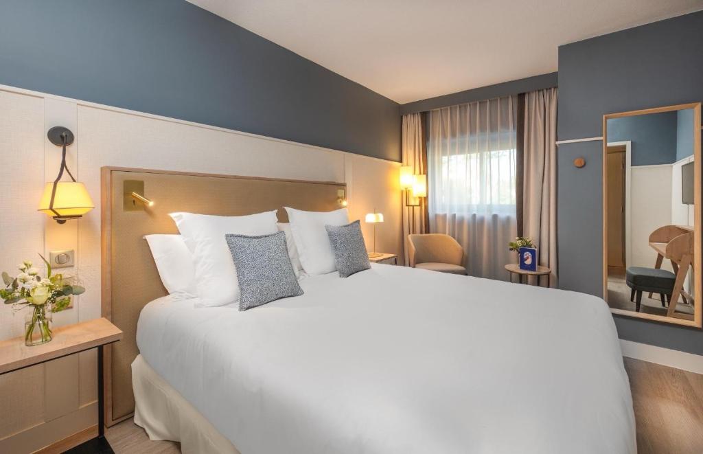 a large white bed in a hotel room at Hôtel Arcanse by Inwood Hotels in Arcachon