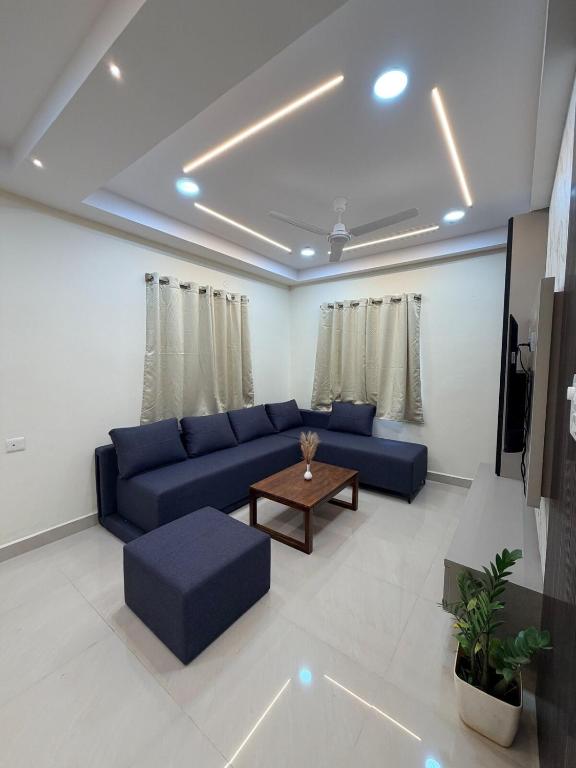a living room with a blue couch and a table at Veechi Retreat in Secunderabad