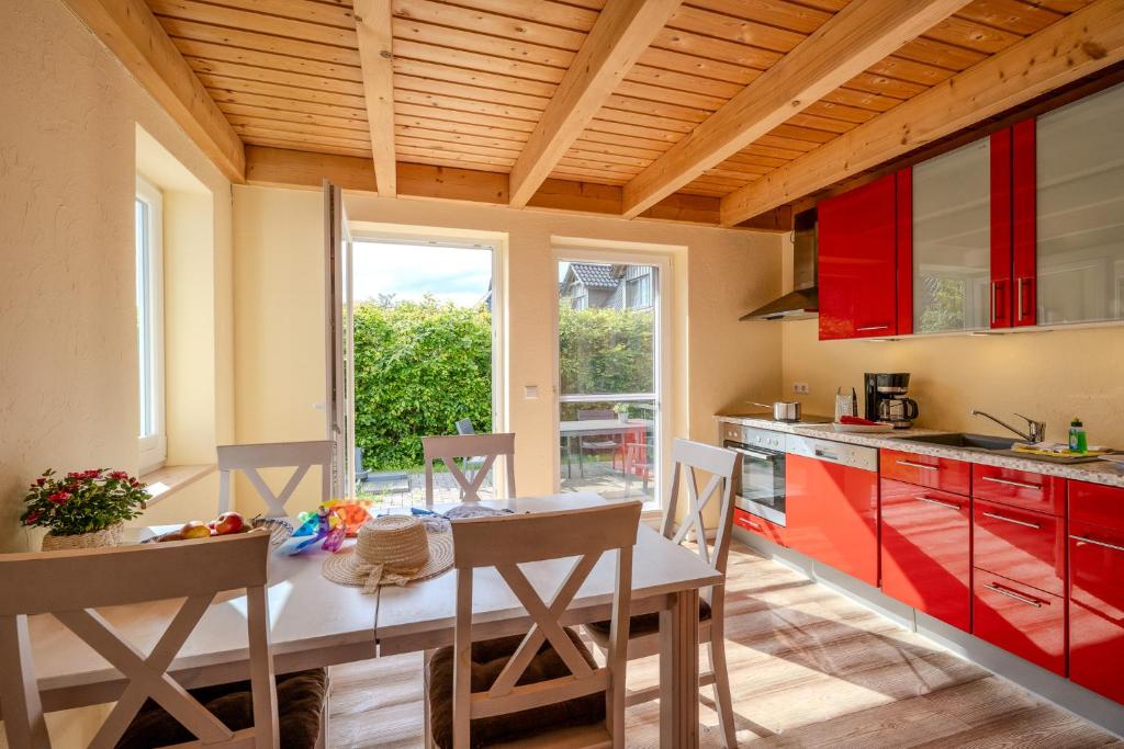a kitchen with red cabinets and a table with chairs at Heideröschen Park Heideröschen 5c in Zingst