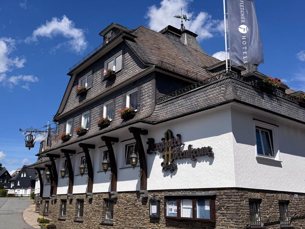 a building with a sign on the side of it at Fletcher Berghotel Astenkrone-Winterberg in Winterberg