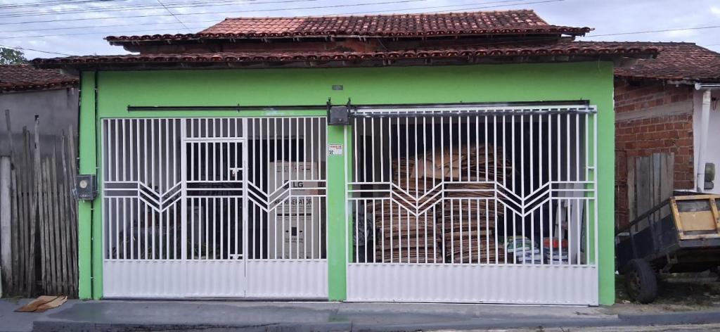 a green and white gate with a dog behind it at CasaLima in Bragança