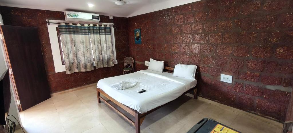 a bed in a room with a brick wall at Hotel Casa viora at swimming pool in Calangute