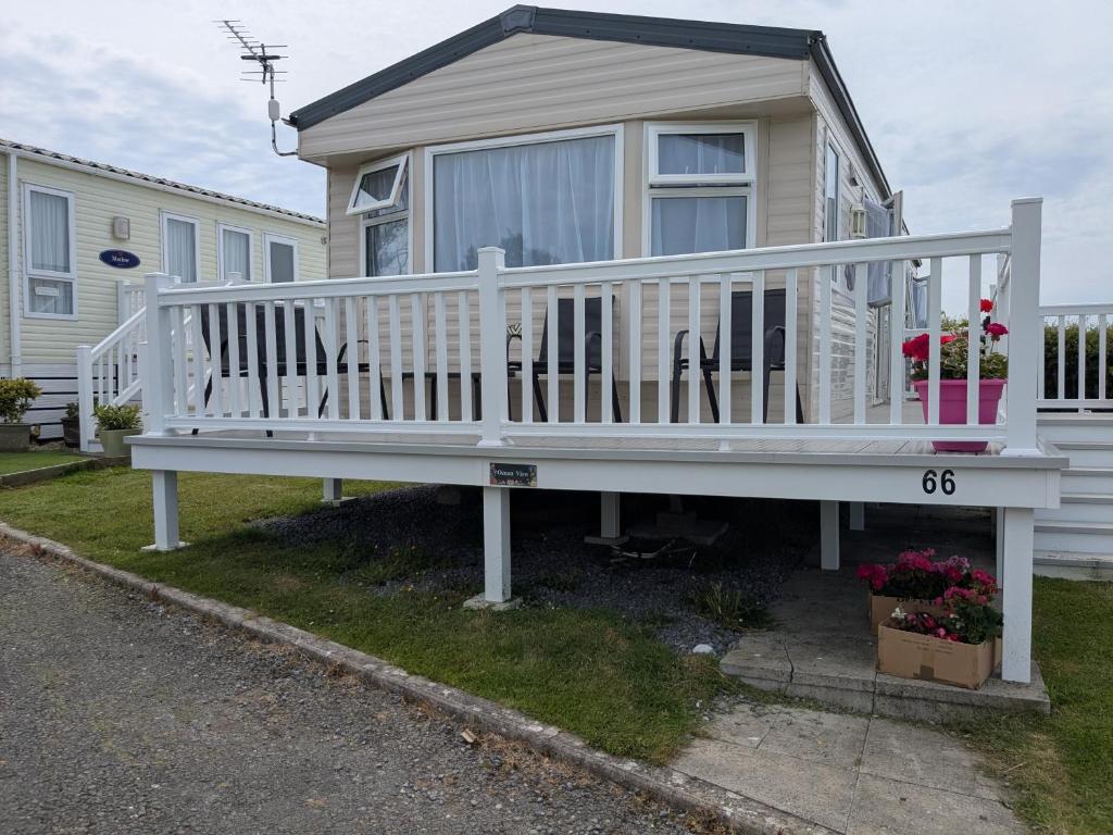a house with a white porch with a bench at Ocean View in Aberaeron