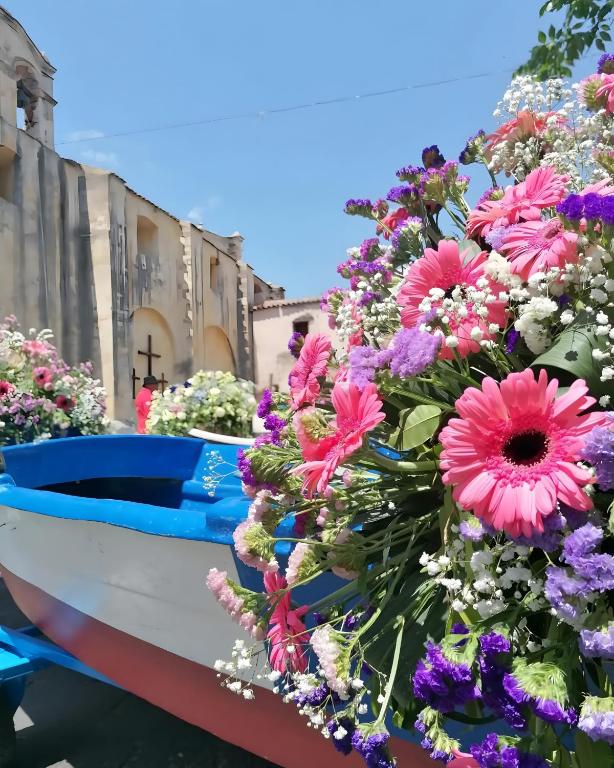 a bunch of flowers on a boat in a garden at Barrosu Studio Apartment in Orosei