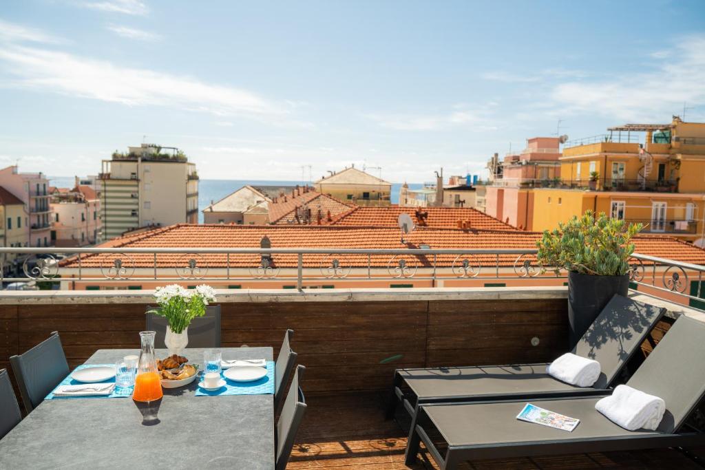 a balcony with two tables and a view of a city at Residence San Marco Suites&Apartments Alassio in Alassio