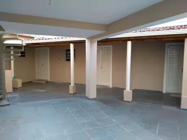 a empty room with white doors and columns in a building at Suites no centro, Salto-SP in Salto