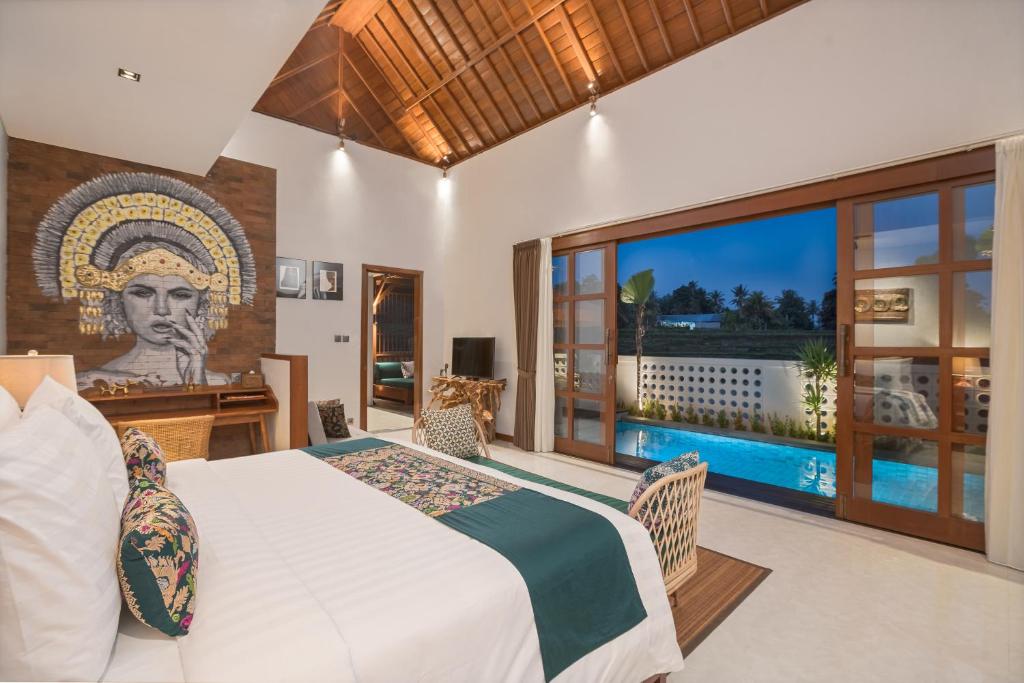 a bedroom with a large bed and a pool at Dijero at Umah Bali in Ubud