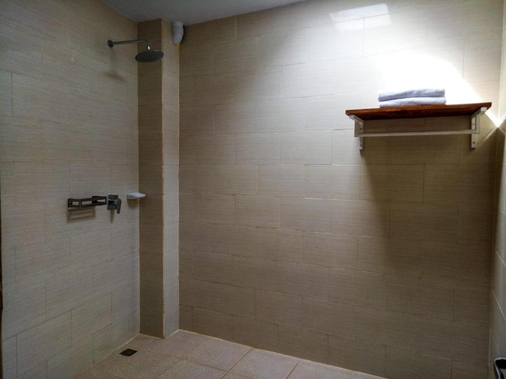 a bathroom with a shower with a light on the wall at The Ambara Bali in Canggu