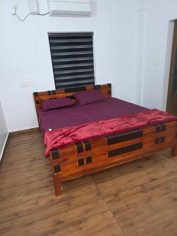 a bedroom with a wooden bed in a room at Ruby Residency in Perintalmanna