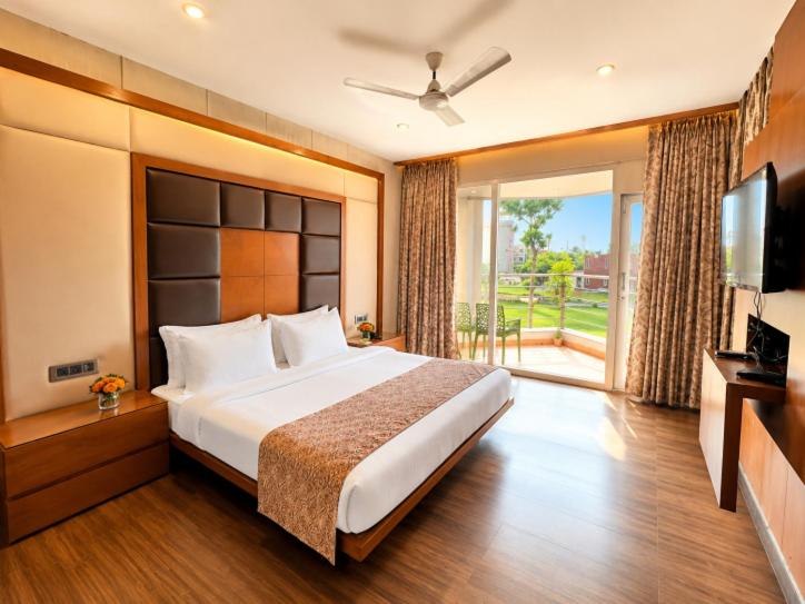 a large bedroom with a large bed and a television at Golden Palace Puri - Private Flagship Beach - Swimming Pool - Sea View Rooms - Restaurant - Luxurious Stay in Puri