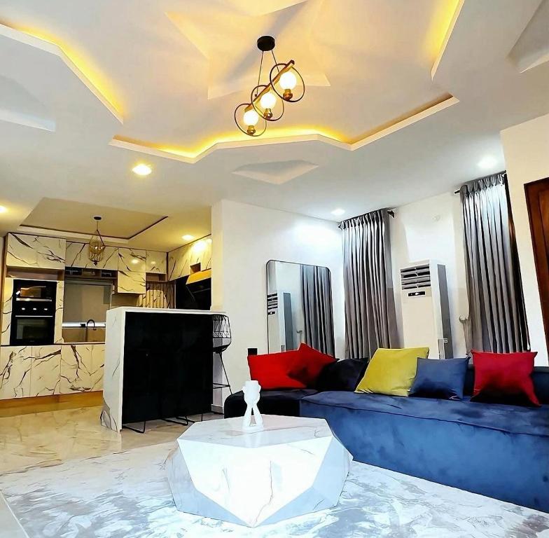 a living room with a blue couch and a tv at OSOJAPA Residence in Asaba
