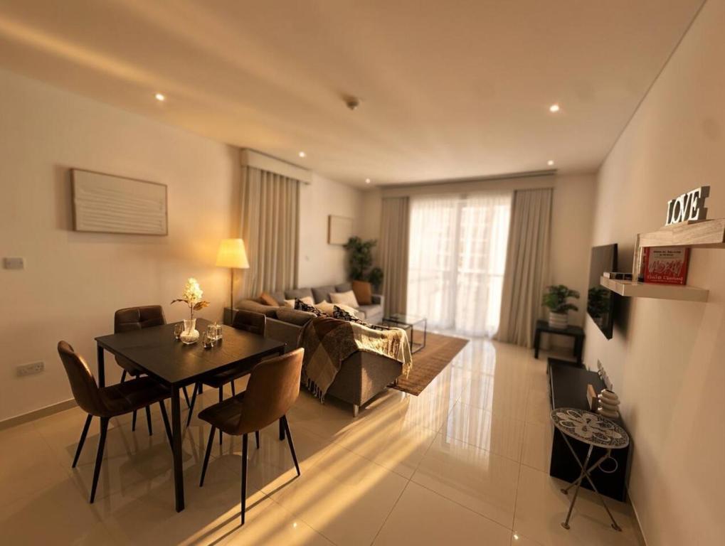 a living room with a table and a couch at Thewalk2 Pool View ~ 5 mins from Airport in Seeb
