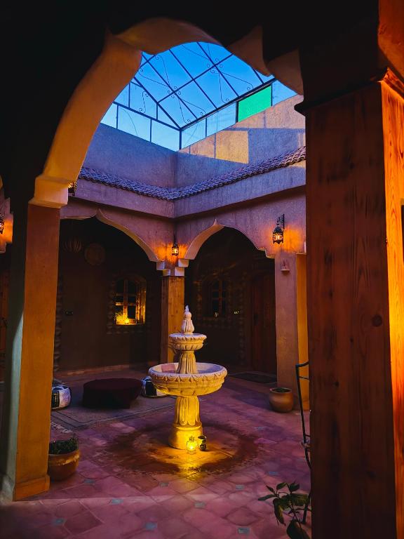 a fountain in the middle of a courtyard at Dar Dallali maison d'hôtes et excursions in Mhamid