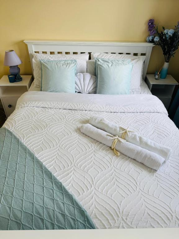 a large white bed with two towels on it at Erris Ocean House in Belmullet