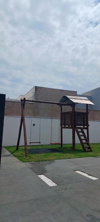 a wooden bench with an umbrella on the grass at Ks Espaço in Rondonópolis