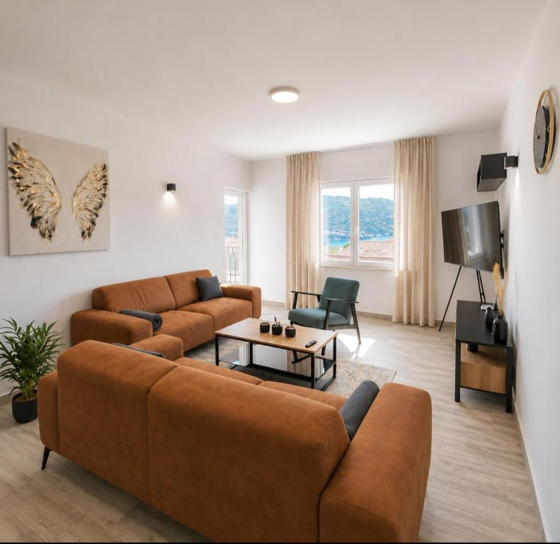 a living room with two brown couches and a table at 3-bedroom Sea View Home with Private Parking in Mokošica