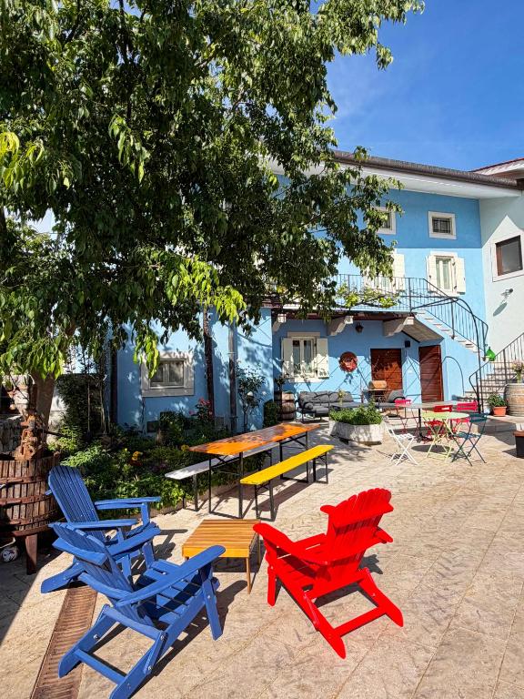 a group of chairs and a picnic table in front of a house at Agriturismo Fruske in Aurisina