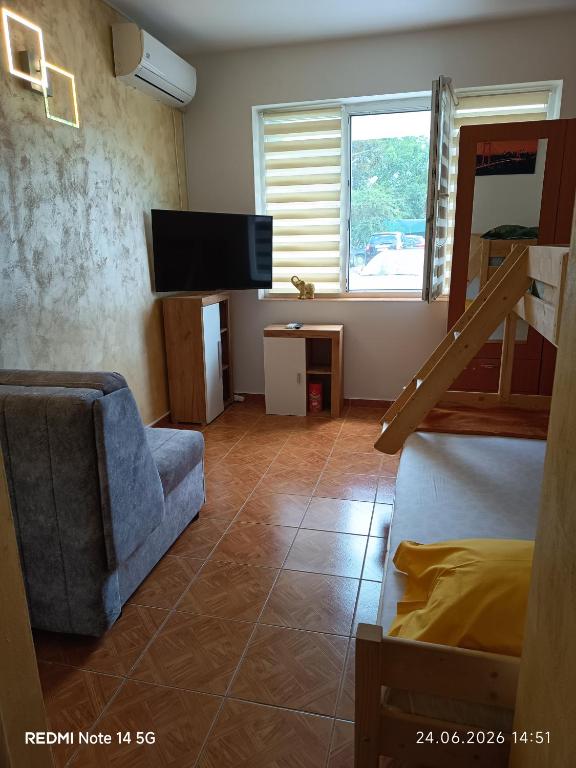 a bedroom with a bed and a tv and a chair at Studioul vacanțelor din Saturn 2 in Saturn