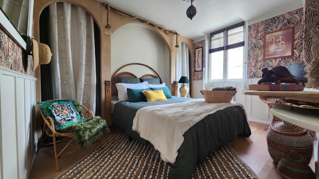 a bedroom with a bed and a chair at Appartement in Craon