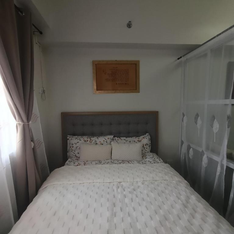 a bed with two pillows in a bedroom at Sanctuary 5125 by Primeworld District in Agus
