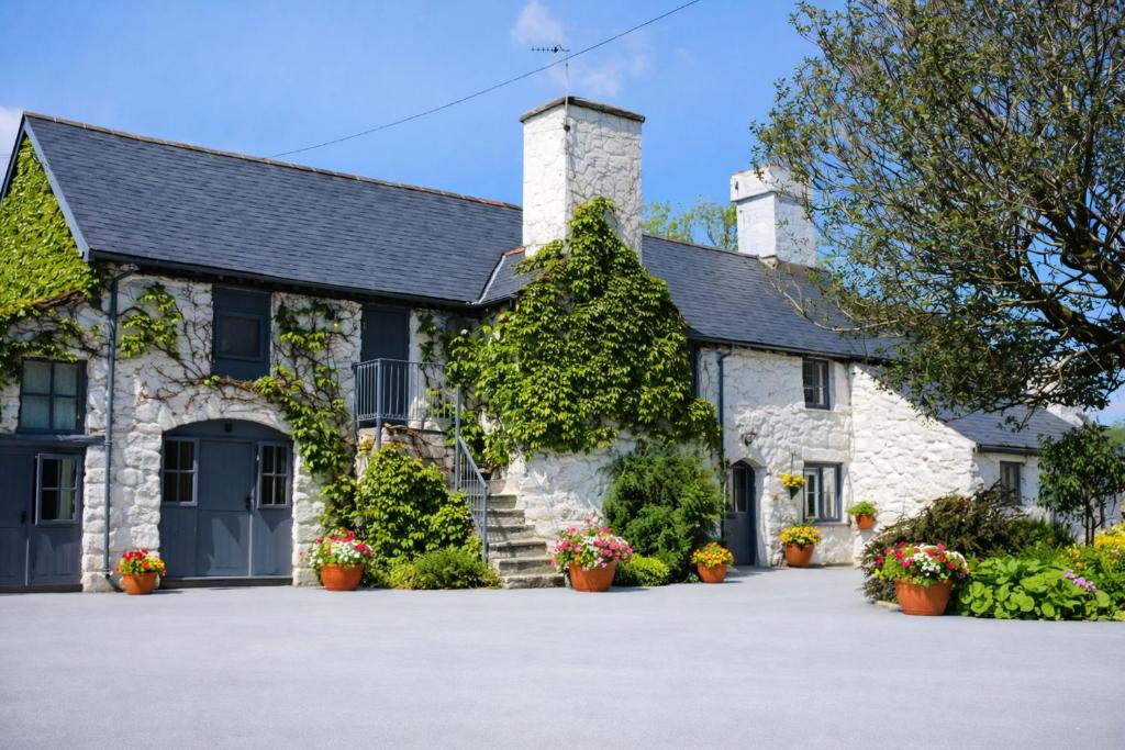 an old stone house with a driveway at Dolgun Uchaf Historic B&B and Cottages with Boutique Bedrooms In The Heart of Snowdonia in Dolgellau