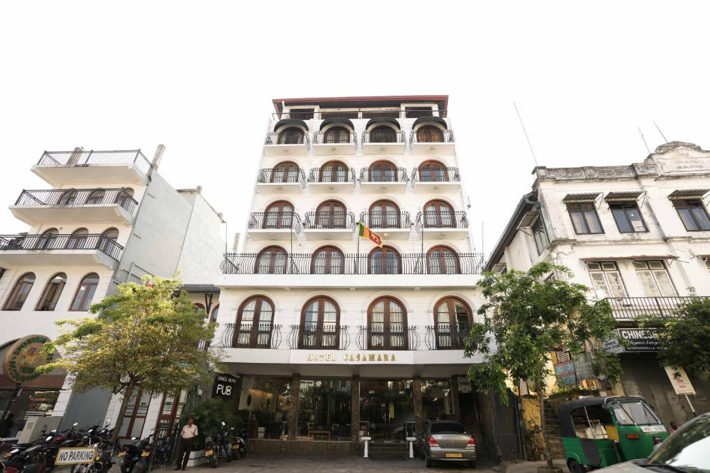 ein hohes weißes Gebäude in einer Stadtstraße in der Unterkunft Hotel Casamara - Center Point Kandy in Kandy