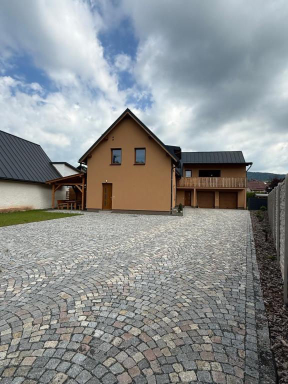 a house with a stone driveway in front of it at Apartmány u Anety in Mladé Buky