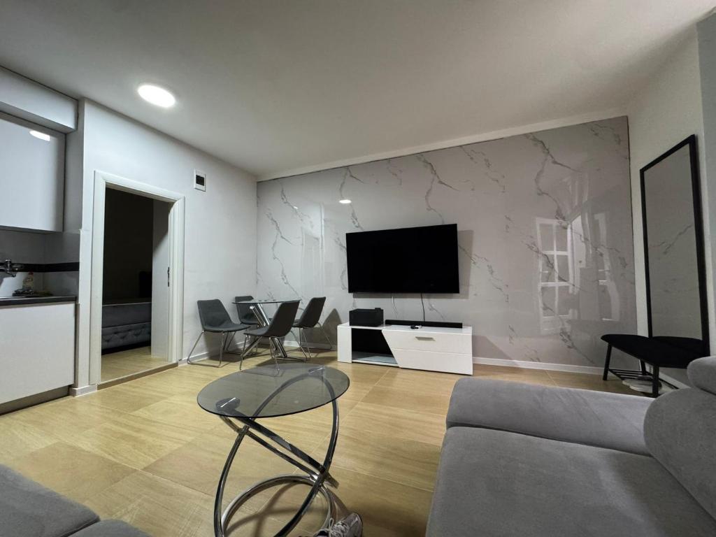 a living room with a couch and a tv on a wall at Hide Avenue Dedinje in Dedinje
