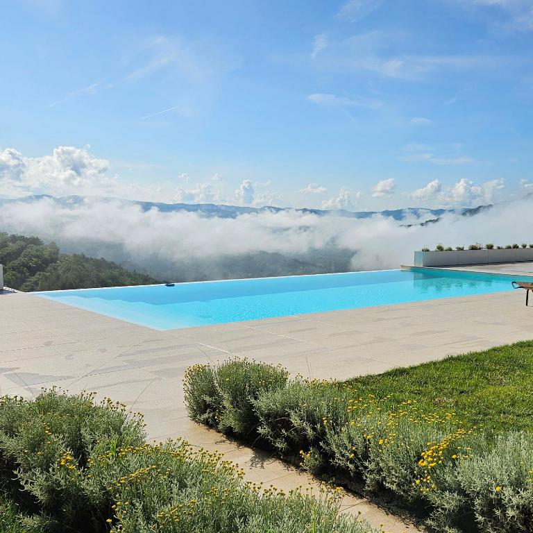 a view of a swimming pool with clouds in the background at Villa with Private Pool & Lake View near Motovun, Casa Mille Olivi Heritage in Buzet