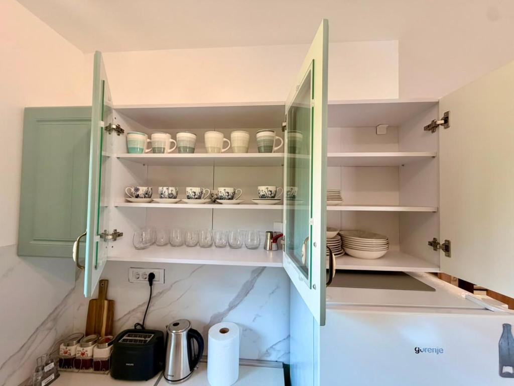 a kitchen with a glass cabinet with dishes in it at Captain's Oasis in Budva