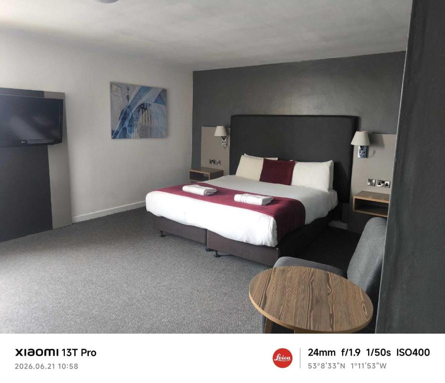 ein Hotelzimmer mit einem Bett und einem Tisch in der Unterkunft Midland Hotel in Mansfield