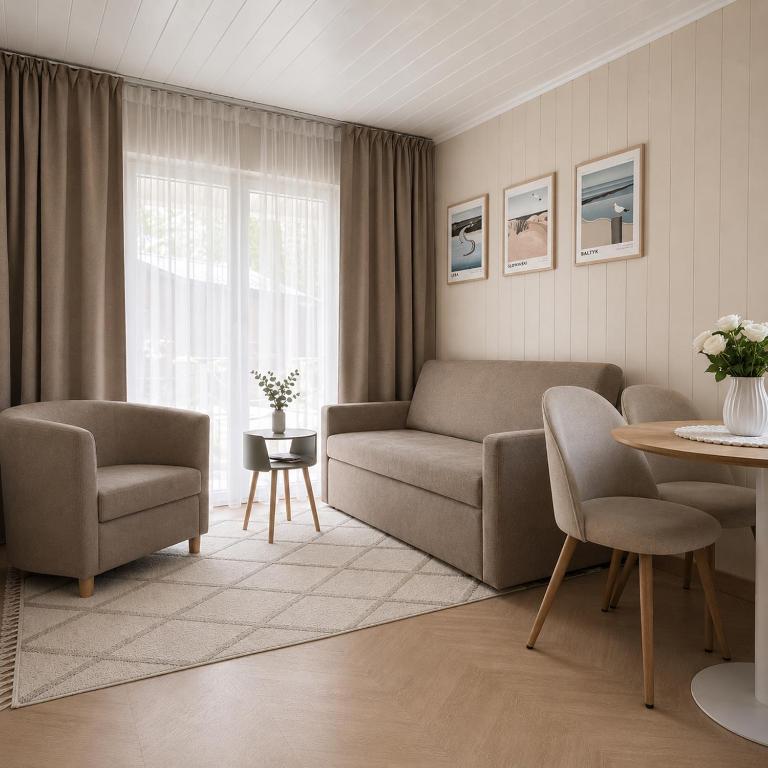 a living room with a couch and chairs and a table at Szarotka Łeba - nowe domki blisko plaży in Łeba