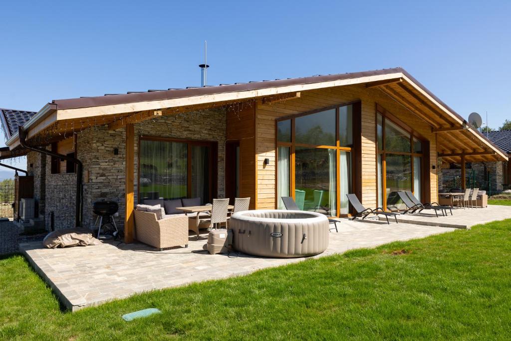 a house with a large patio with a fire pit at Villa Sofayla w Jacuzzi near the Pirin Golf Resort in Bansko