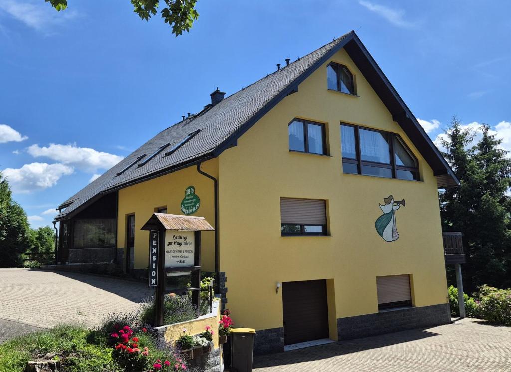 a yellow building with a sign in front of it at Pension Gerlach in Seiffen