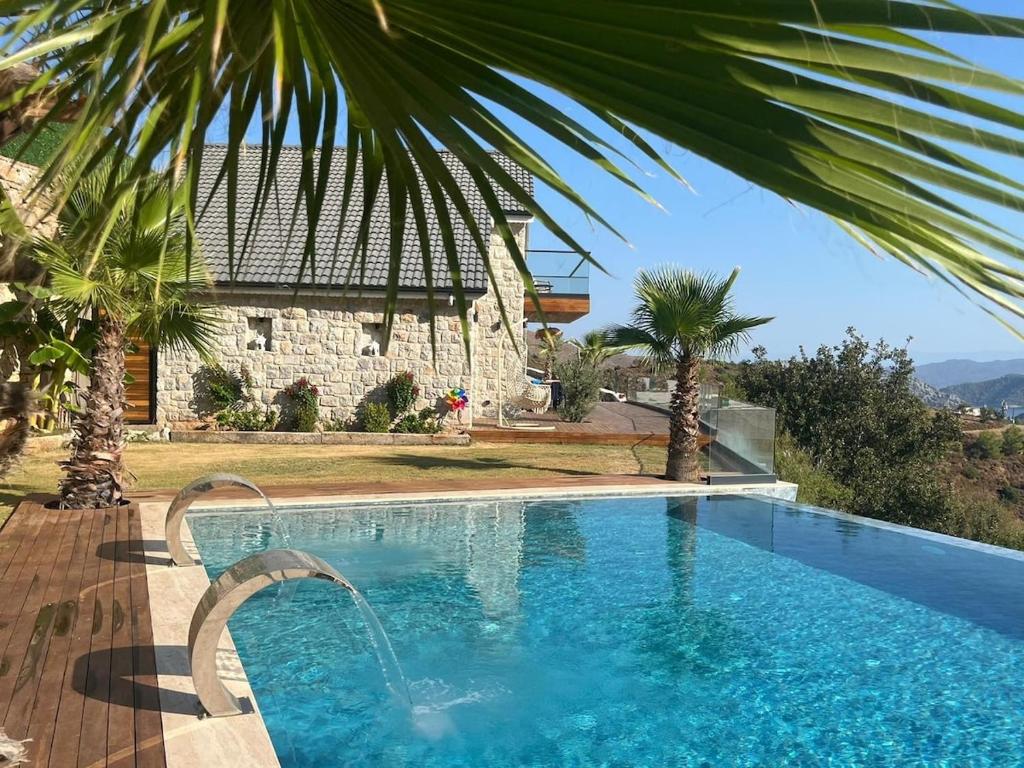 a swimming pool in front of a house at Villa Han Selimiye in Selimiye