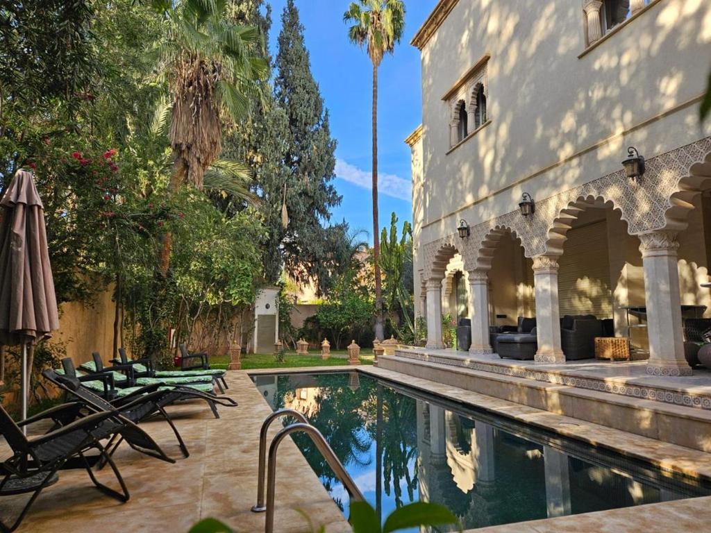 a swimming pool in front of a building at Barthélemy Guest House in Marrakesh