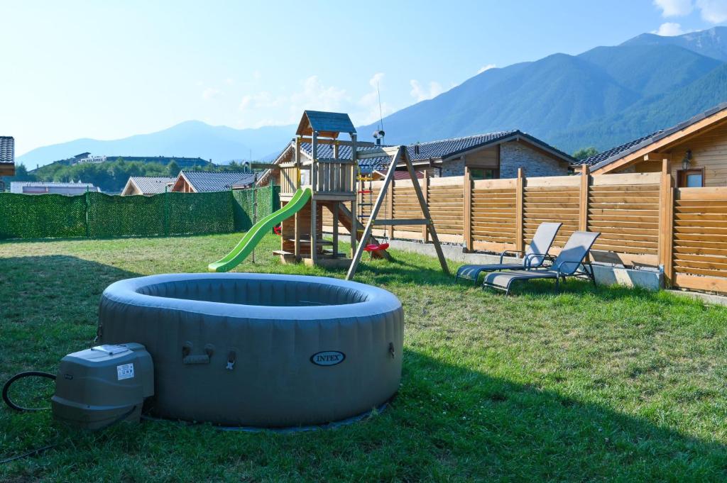 a backyard with a playground with a slide and a play structure at Villa Raphael w Jacuzzi near Pirin Golf Resort in Bansko