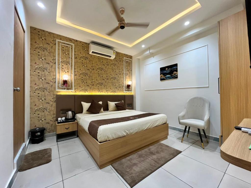 a bedroom with a bed and a chair in it at Atithi in Hisār