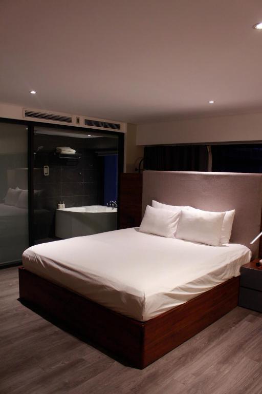 a bedroom with a large bed and a bath room at Casahindout in Hanoi