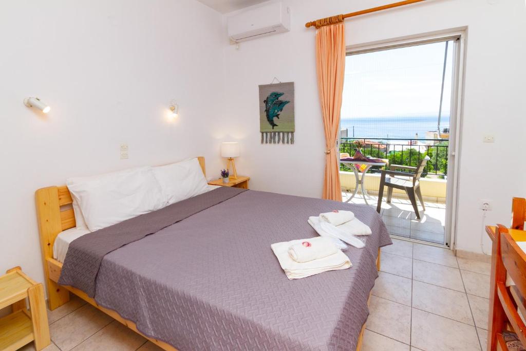 ein Schlafzimmer mit Bett und Meerblick in der Unterkunft Davis Studios & Apartments - Ήλια Βόρειας Εύβοιας - 1' από τη θάλασσα in Region Ilia