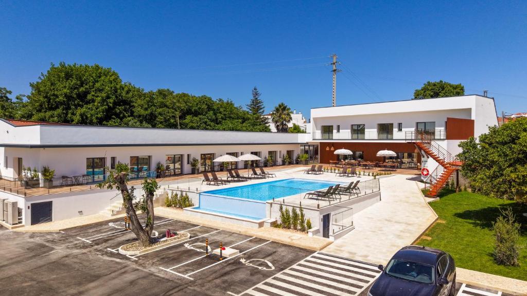 a villa with a swimming pool and a parking lot at Moinho do Canto Residence Hotel in Rio Maior