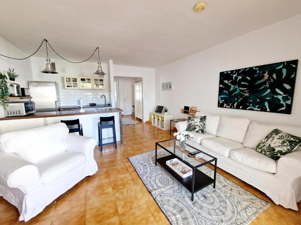 a living room with a white couch and a table at Teguisol Breeze en Costa Teguise in Costa Teguise