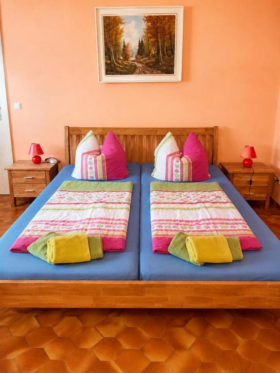 a bedroom with two beds with colorful pillows at Pension Greifswald in Dargelin